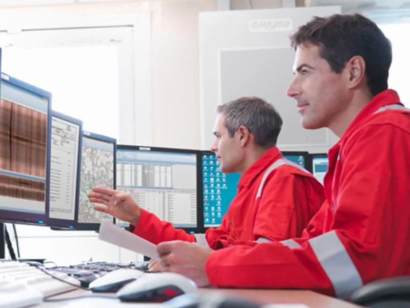 Ingenieros de Pacific Group revisando diseños de redes hidráulicas en pantallas de un centro de control