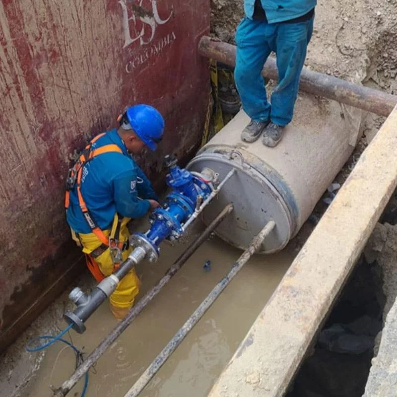 Instalación de válvulas en red de acueducto Técnico de Pacific Group instalando válvulas en una red de acueducto subterránea en Colombia