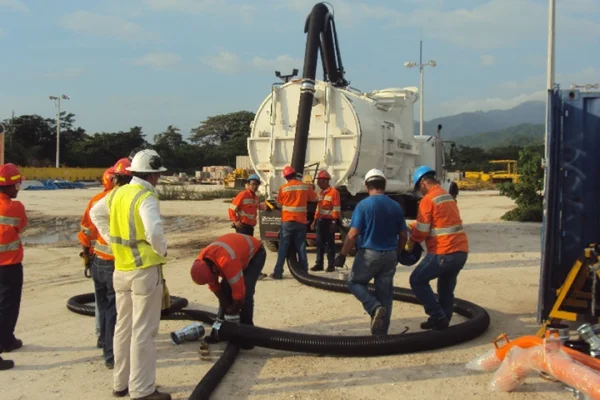 Equipo técnico operando camión de succión industrial para limpieza y manejo de residuos líquidos en proyecto de infraestructura y mantenimiento industrial.