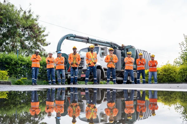 Equipo técnico especializado en mantenimiento de alcantarillado y limpieza industrial junto a camión de succión para servicios de infraestructura hidráulica.